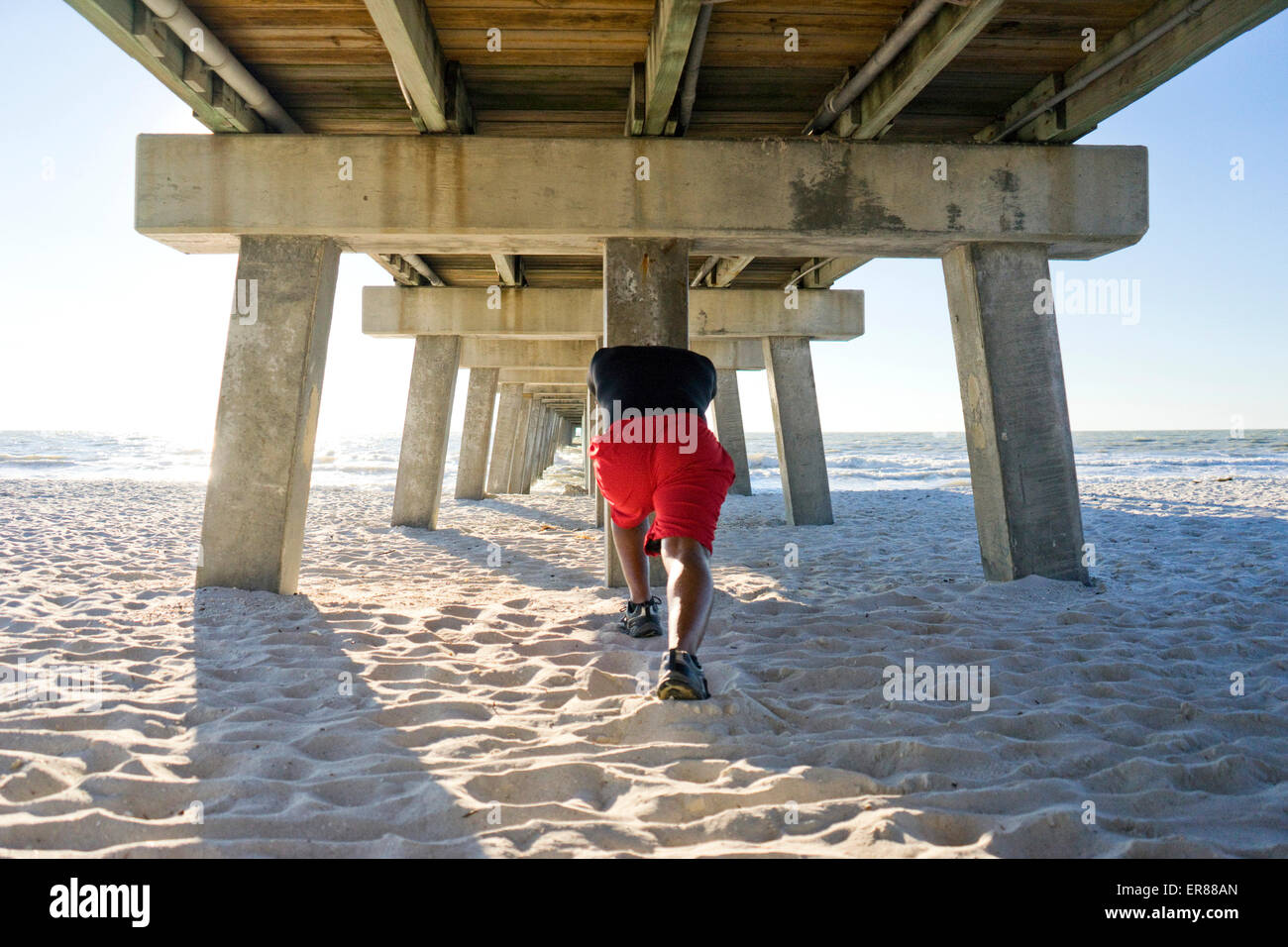 Mann unter einem Beach pier Stockfoto