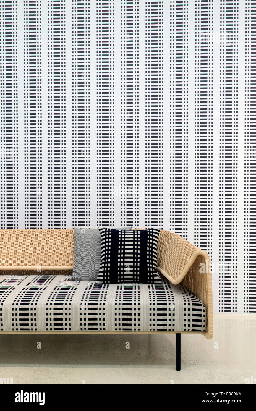 Interieur mit einem hölzernen Sessel und ein Holzsofa mit einer Tapete im Hintergrund Stockfoto