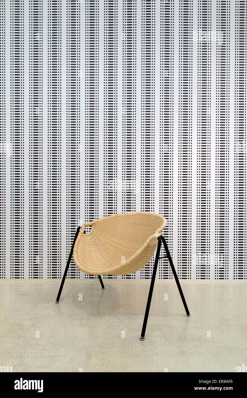 Interieur mit einem zeitgenössischen Holzstuhl mit einer Tapete im Hintergrund Stockfoto
