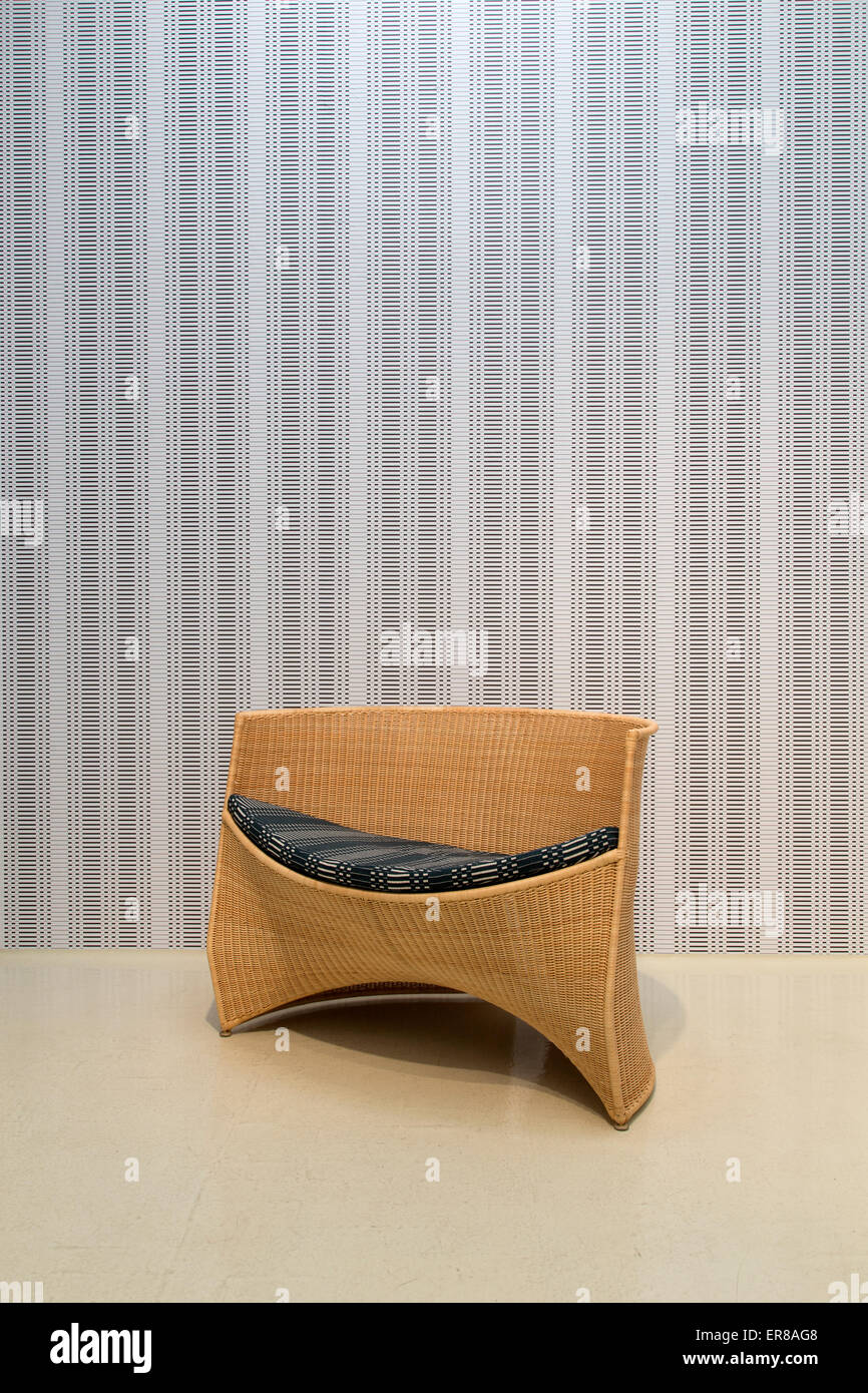 Interieur mit einem zeitgenössischen Holzstuhl mit einer Tapete im Hintergrund Stockfoto