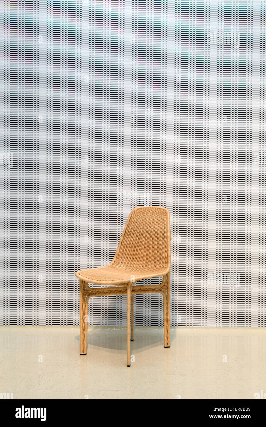 Interieur mit einem zeitgenössischen Holzstuhl mit einer Tapete im Hintergrund Stockfoto