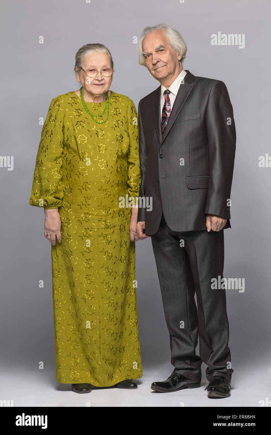 In voller Länge Portrait von senior Brautpaar stehend auf grauem Hintergrund Stockfoto