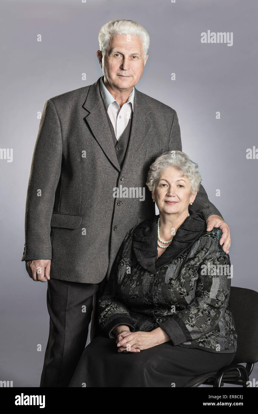 Porträt von älteres Paar vor grauem Hintergrund Stockfoto