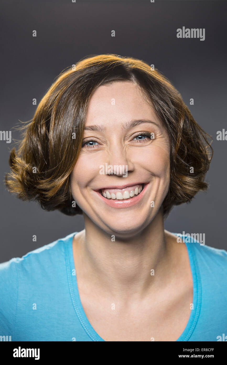 Porträt von glücklich Mitte Erwachsene Frau auf grauem Hintergrund Stockfoto