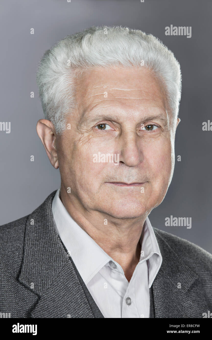 Close-up Portrait von zuversichtlich senior Mann über grauen Hintergrund Stockfoto
