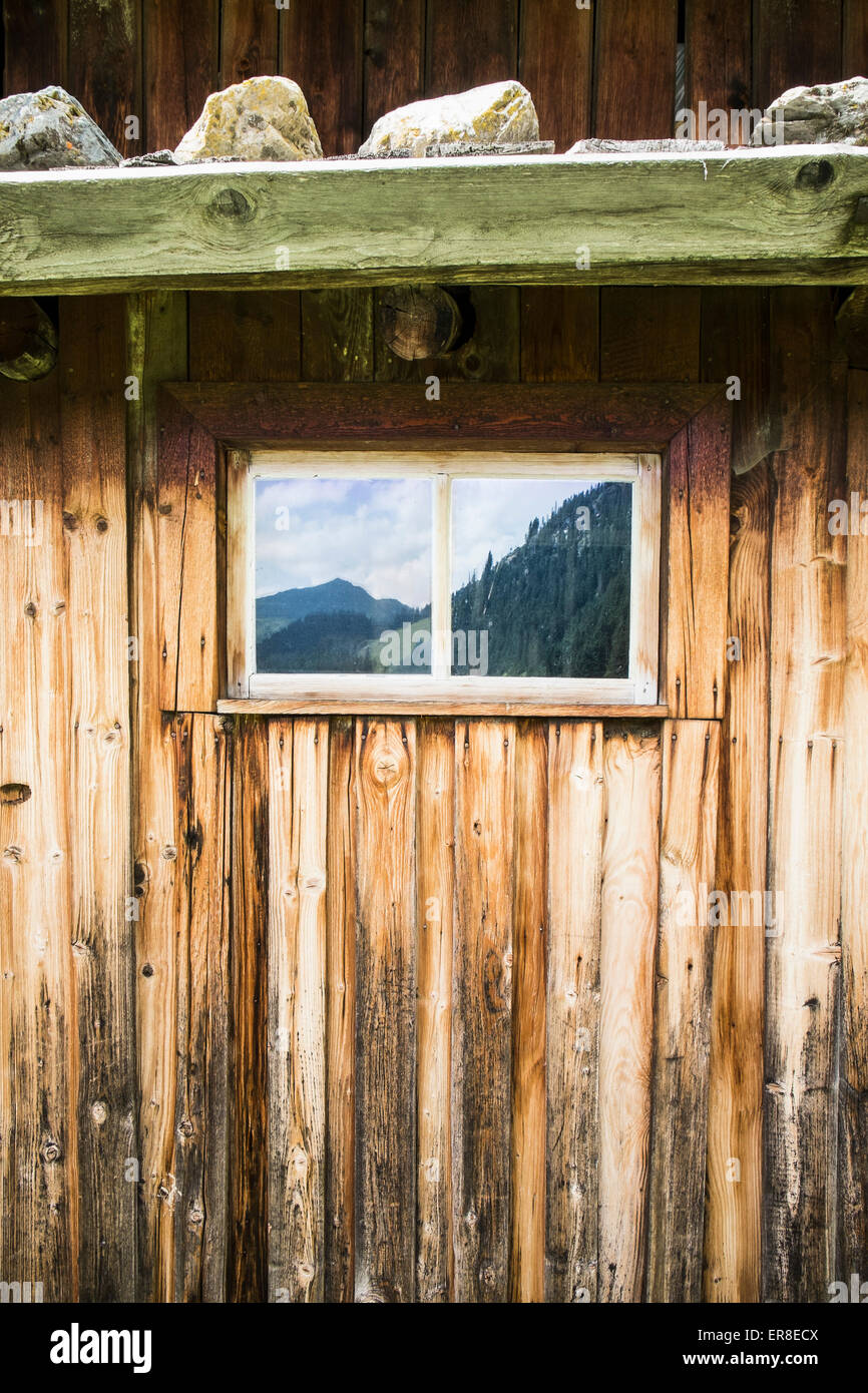 Full-Frame-Foto von Blockhaus mit Reflexion der Berge am Fenster Stockfoto