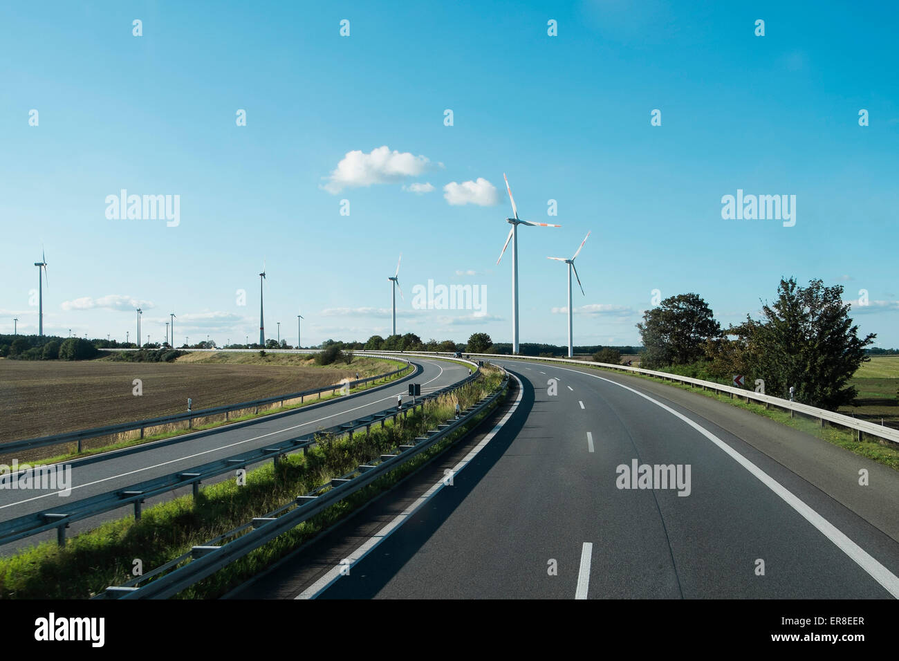 Windkraftanlagen über die leere Autobahn Stockfoto