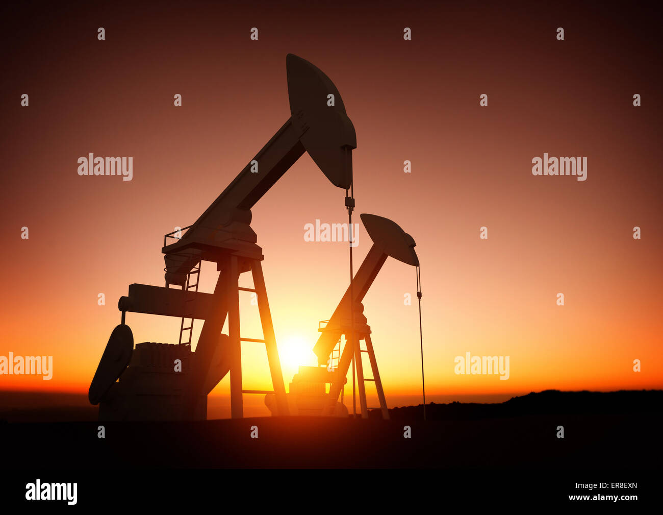 Öl- und Energieindustrie. Ein Feld von Ölpumpen gegen einen Sonnenuntergang. Ölpreise, Energie und wirtschaftliche Rohstoffe. Stockfoto