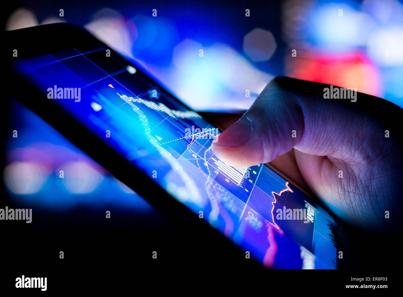 Eine Person, die Börsendaten auf einem mobilen Gerät zu überprüfen. Stockfoto