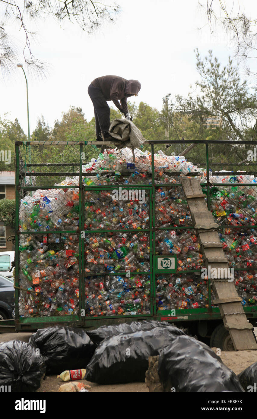 Mann arbeitet auf Haufen von recyclebaren Kunststoffabfällen auf Mülldeponie Stockfoto