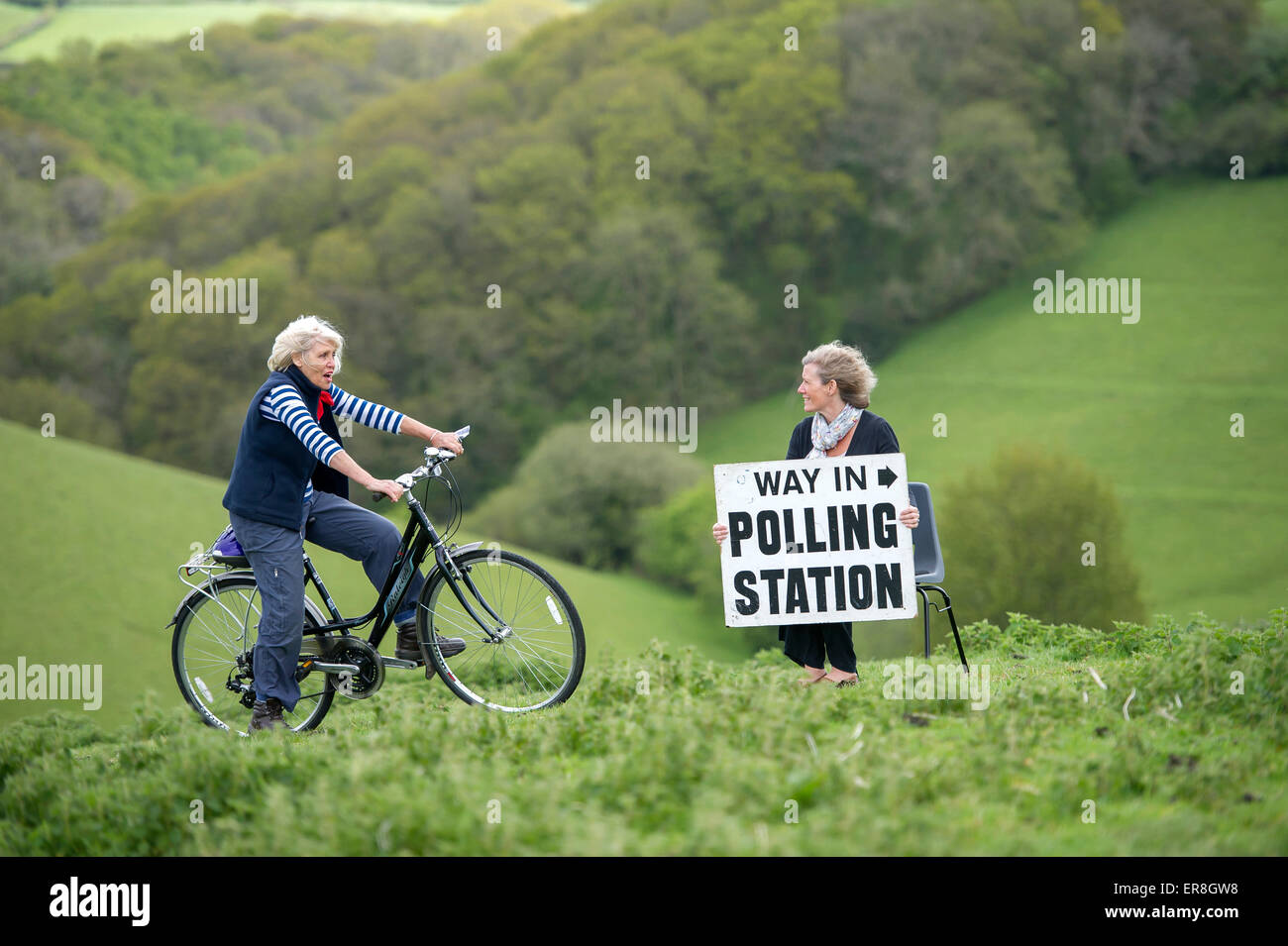 Parlamentswahlen 2015 UK: Ein Wähler mit ihrem Fahrrad unterwegs, in einem ländlichen Wahllokal in Shirwell, Devon zu stimmen. Stockfoto