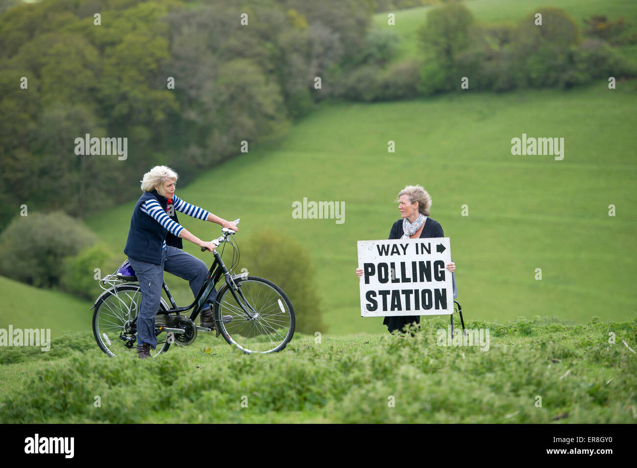 Parlamentswahlen 2015 UK: Ein Wähler mit ihrem Fahrrad unterwegs, in einem ländlichen Wahllokal in Shirwell, Devon zu stimmen. Stockfoto