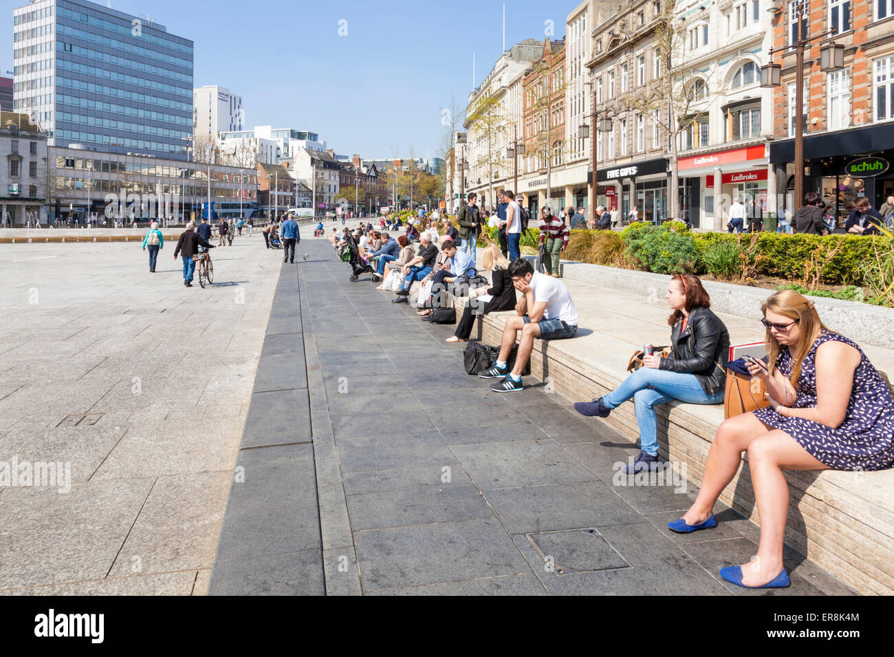 Menschen sitzen genießen Sie die Frühlingssonne im Old Market Square, Nottingham, England, Großbritannien Stockfoto