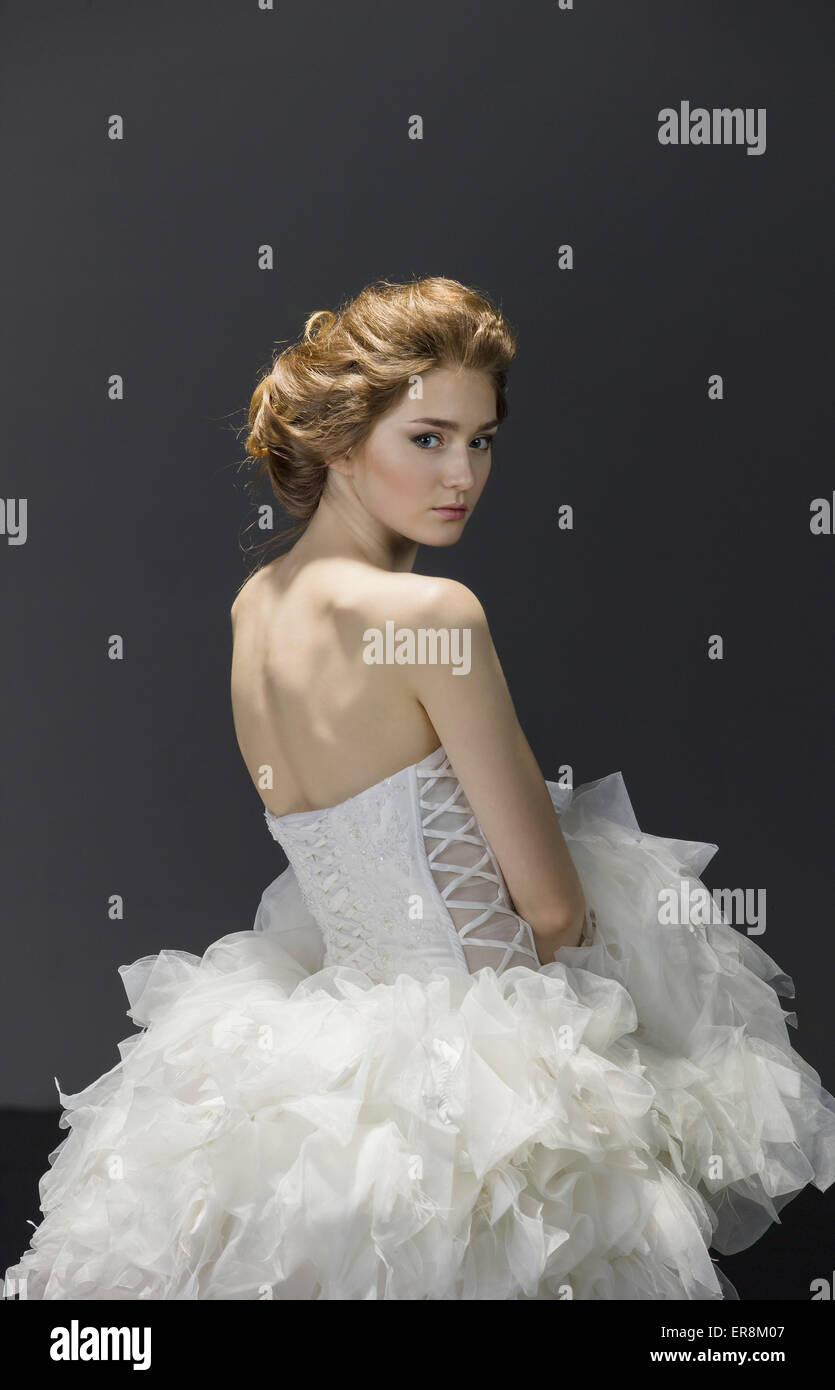 Porträt der jungen Braut im Hochzeitskleid über farbigen Hintergrund Stockfoto