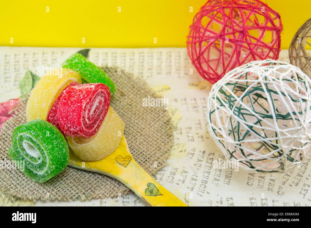 Bunte Jelly rollt auf einem handgefertigten Decoupage-Holzlöffel Stockfoto
