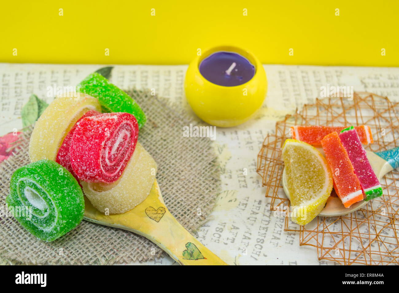 Bunte Jelly rollt auf einem handgefertigten Decoupage-Holzlöffel Stockfoto