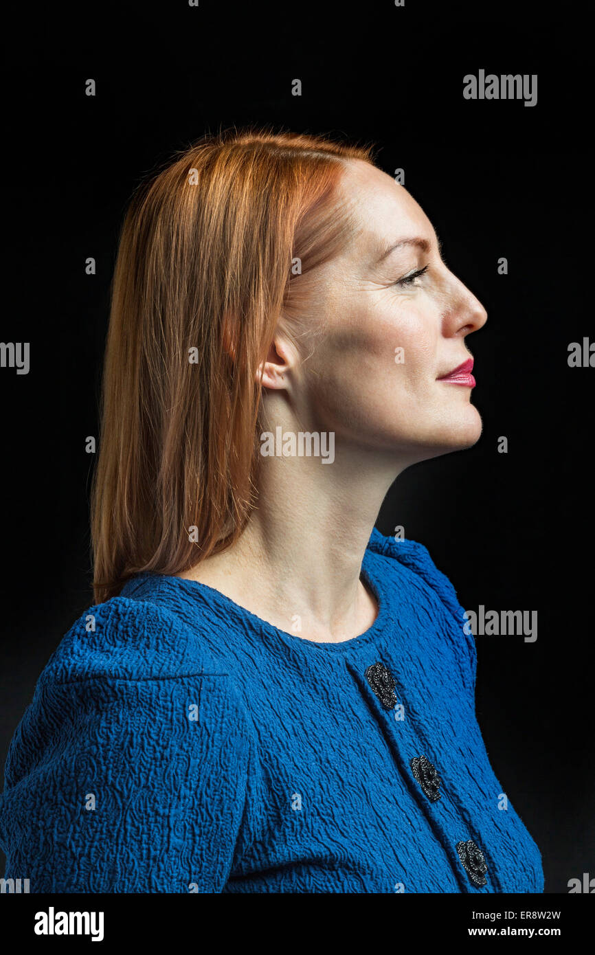 Selbstbewusste Reife Frau vor schwarzem Hintergrund Stockfoto