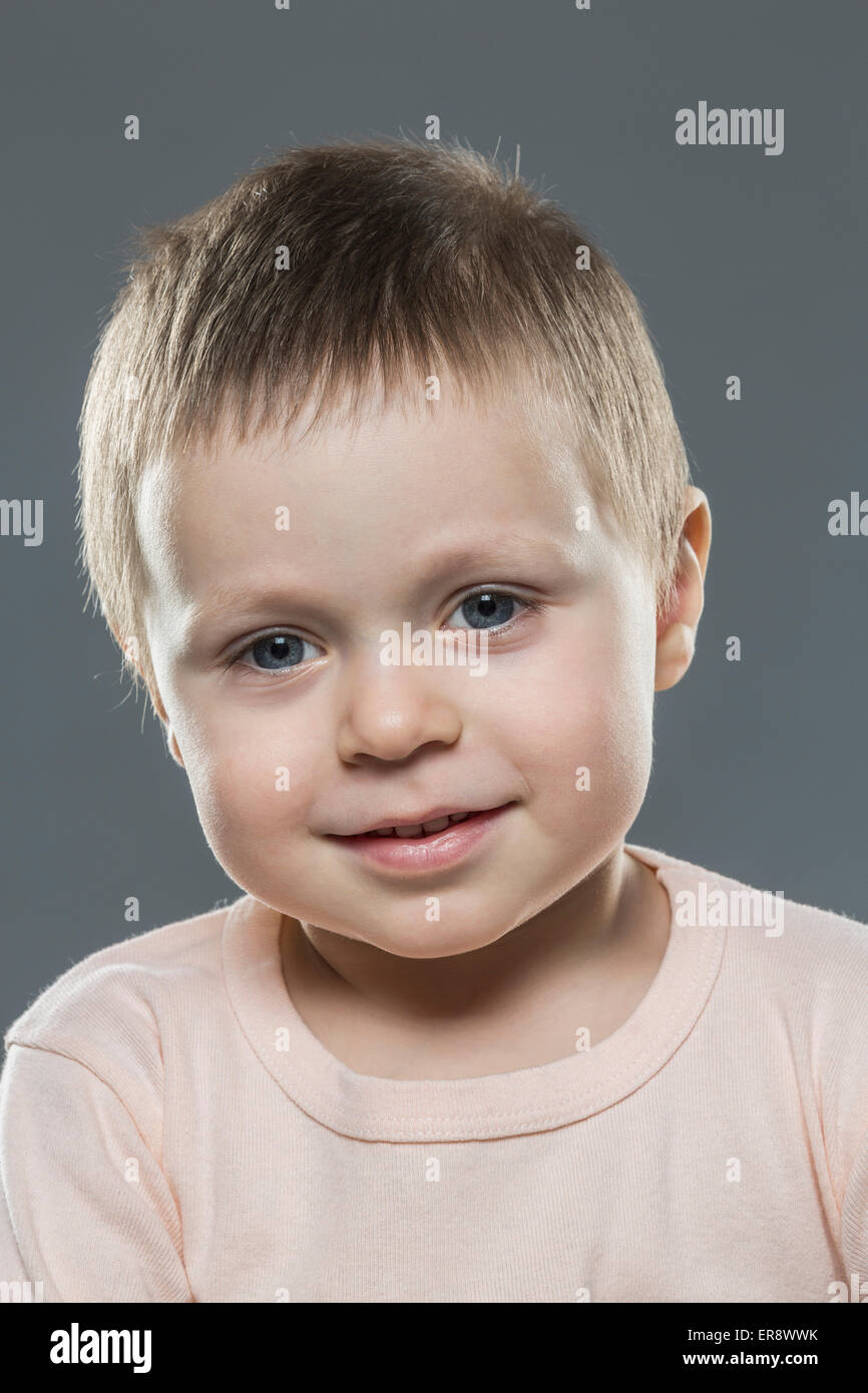 Porträt von süsser Boy vor grauem Hintergrund Stockfoto