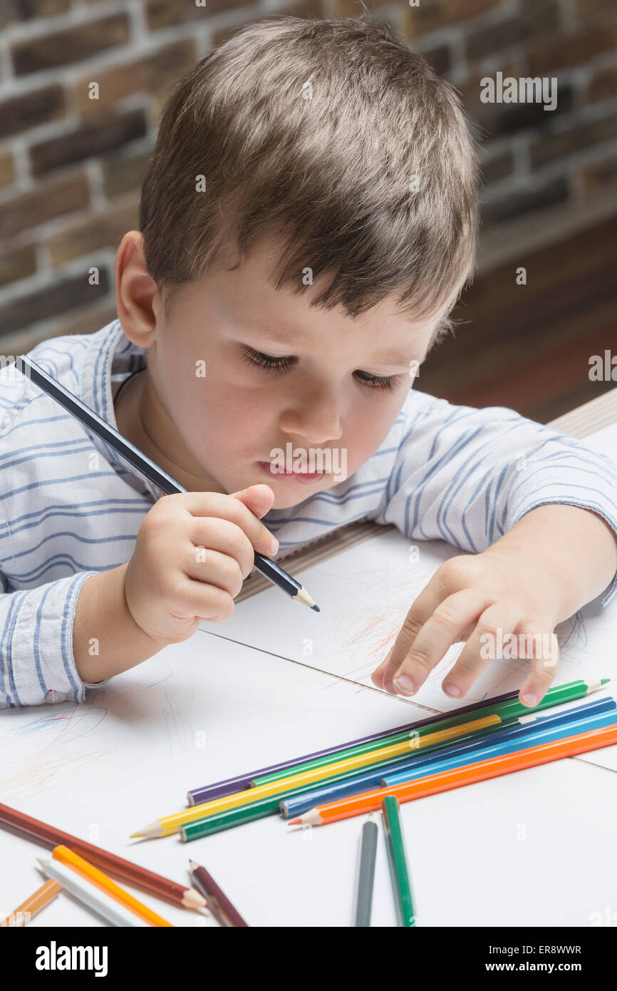 Junge Färbung auf Papier am Tisch im Haus Stockfoto