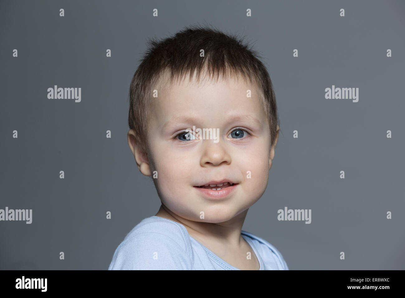 Porträt von süsser Boy vor grauem Hintergrund Stockfoto