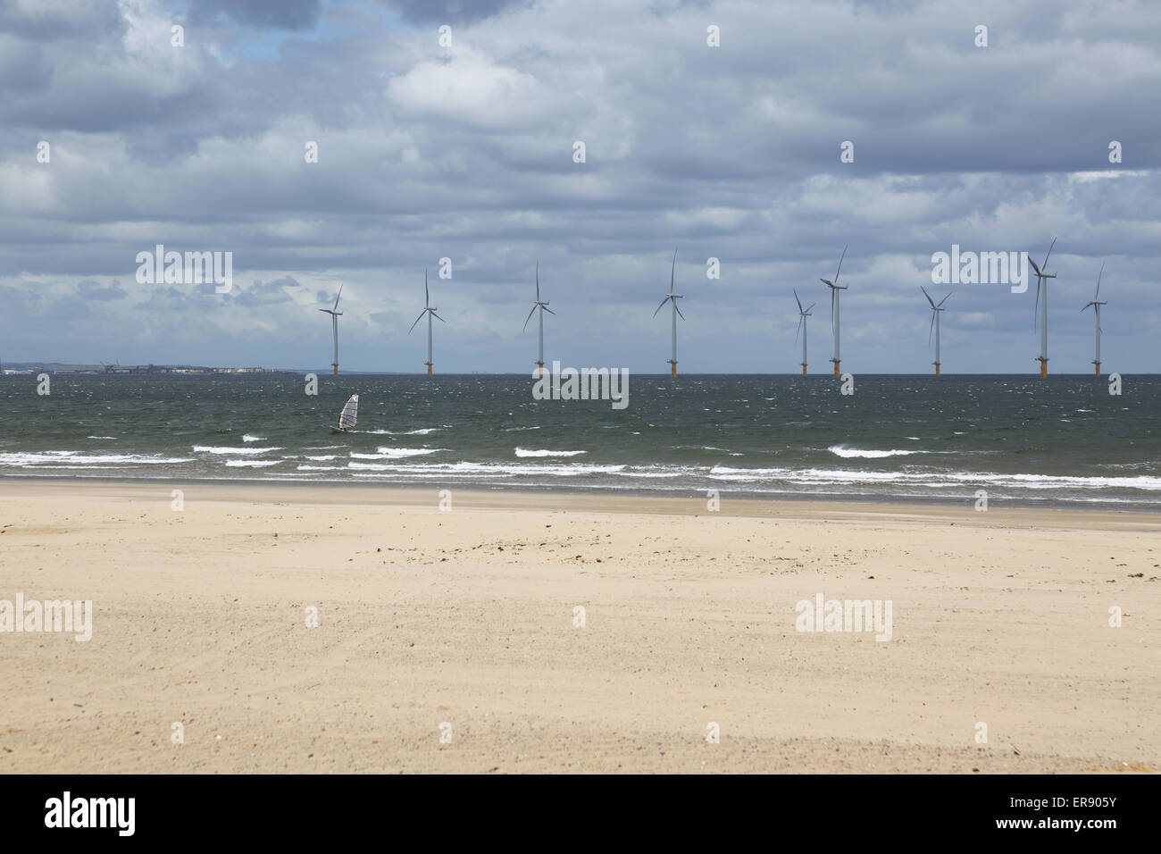 Ein Windsurfer übergibt die Teeside Windpark aus Redcar Strand fotografiert. 27 Offshore-Anlagen in der Mündung des Flusses Abschlag Stockfoto