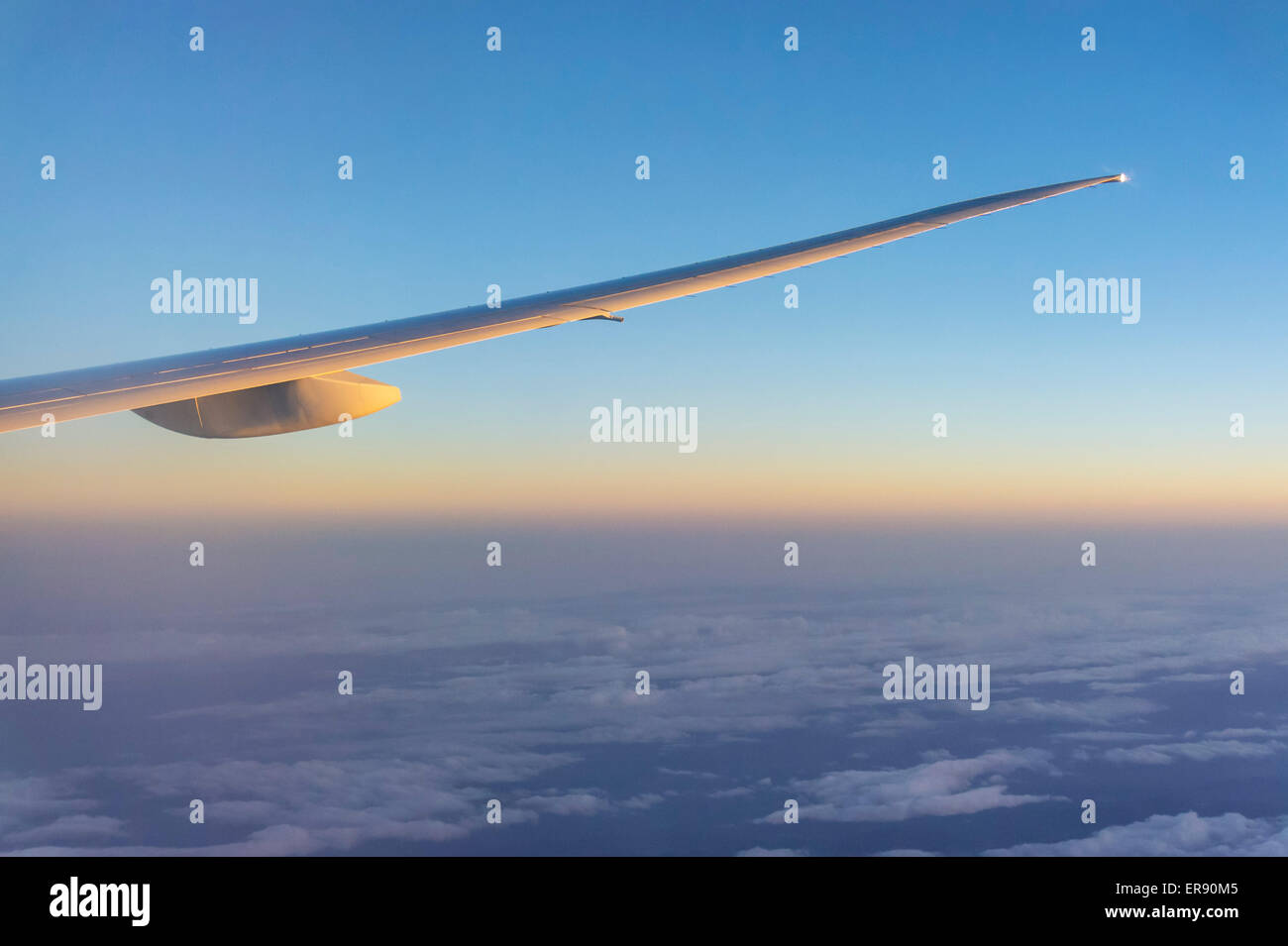 Flugzeugflügel aus Passagierkabine bei Sonnenuntergang Stockfoto