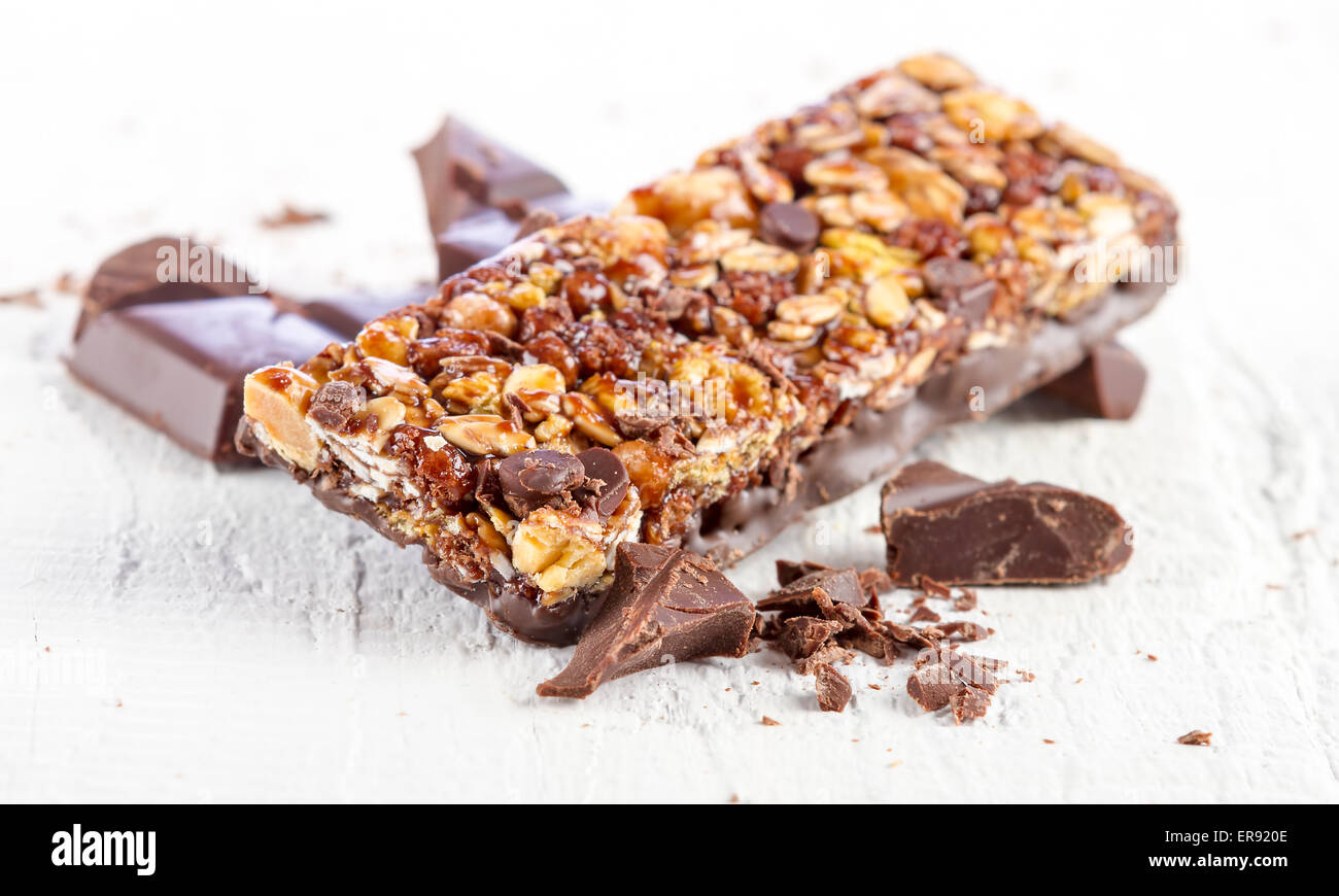 Müsliriegel mit Schokolade auf weißem Holz Hintergrund Stockfoto