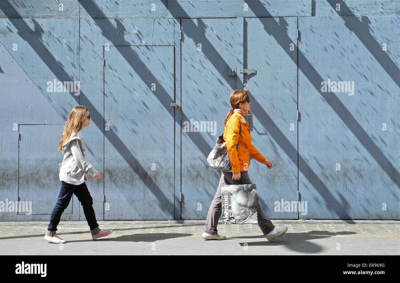 Mutter und Tochter mit langen 45 Grad Schatten London Straße hinunter Stockfoto