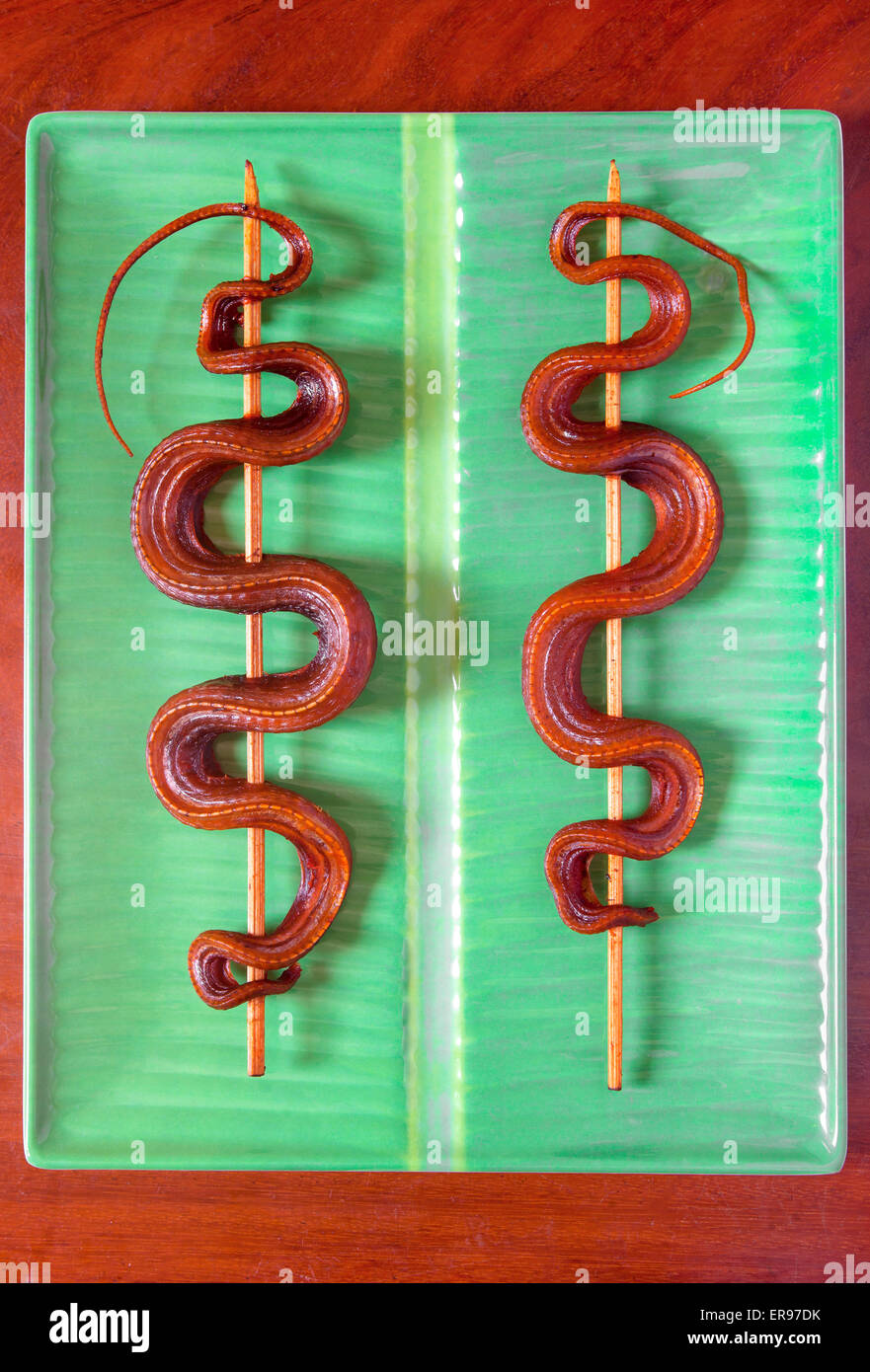 Gekochte Schlangenkebabs, wie sie auf Märkten in Kambodscha verkauft werden - ein Beispiel für die seltsamen oder seltsamen Speisen, die von Menschen auf der ganzen Welt gegessen werden Stockfoto