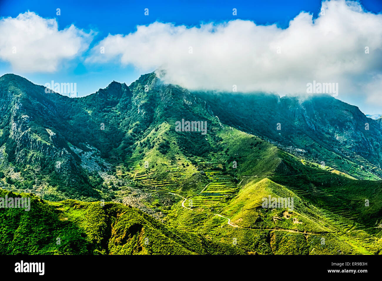Grüne Berge oder Rock mit Wolken über Gipfel und blauer Himmel Stockfoto