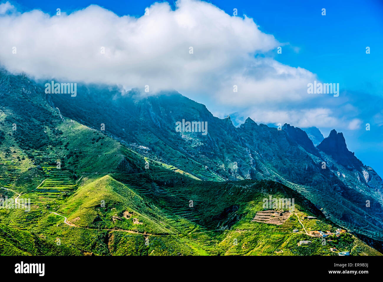 Grüne Berge oder Rock mit Wolken über Gipfel und blauer Himmel Stockfoto