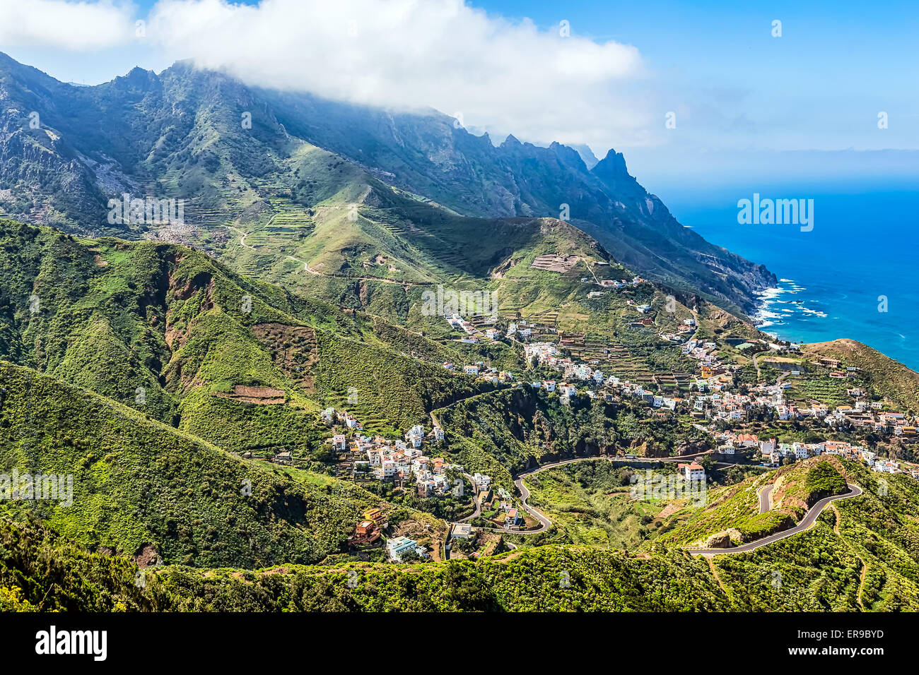 Berg und Wolken mit kleinen Stadt oder Dorf und Himmel Horizont Landschaft in der Nähe der Ufer von Atlantik in Teneriffa Kanarische Stockfoto