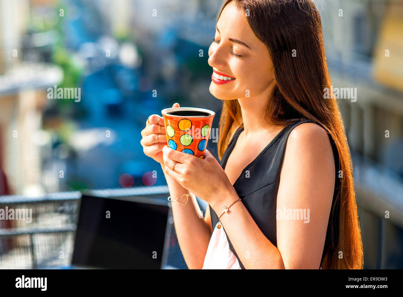 Frau mit bunten Kaffeetasse auf dem Balkon Stockfoto