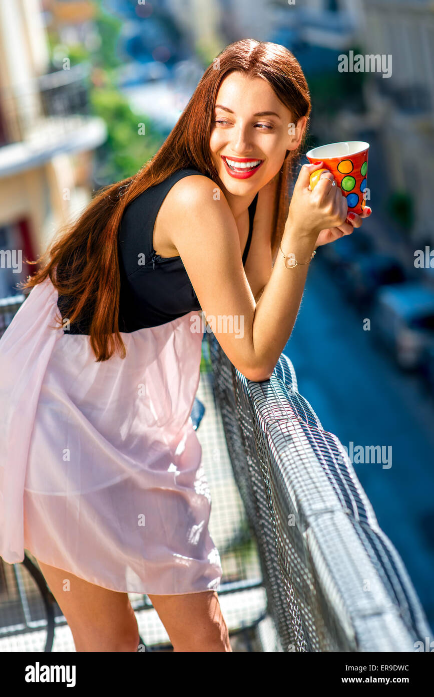 Frau mit bunten Kaffeetasse auf dem Balkon Stockfoto