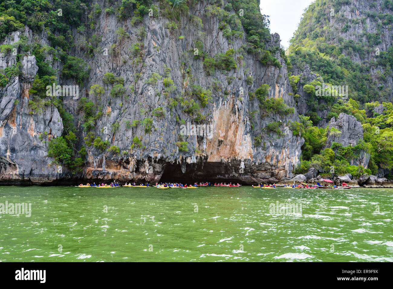 PHANG NGA, THAILAND - 27. April 2015: Touristen freuen sich über das Kanufahren in der Nähe von Insel auf der Meeresoberfläche bei Tham Lod Höhle in Ao Stockfoto