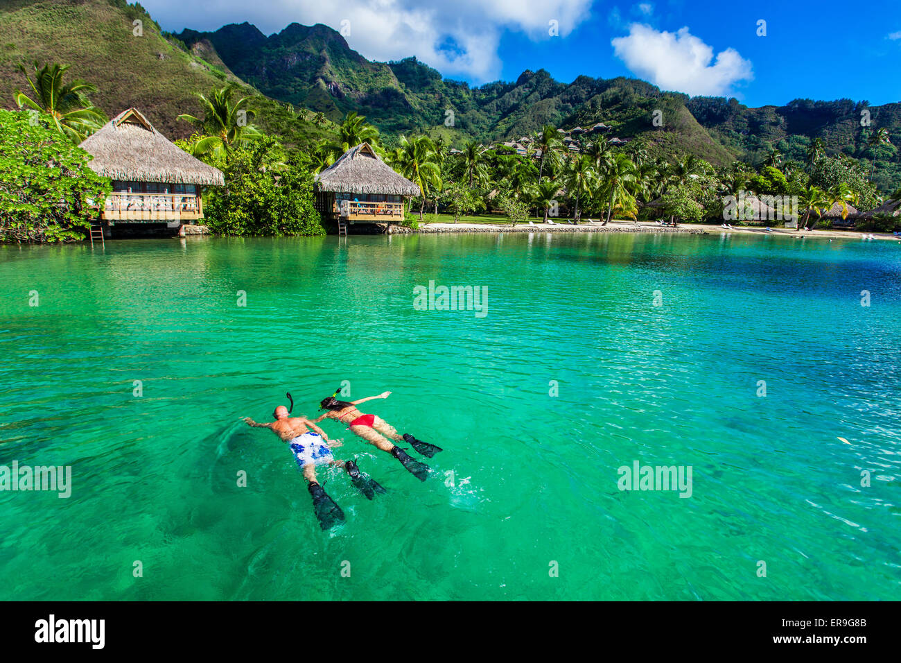 Junges Paar Schnorcheln über Riff weiter, um auf einer tropischen Insel mit over Water Villas resort Stockfoto