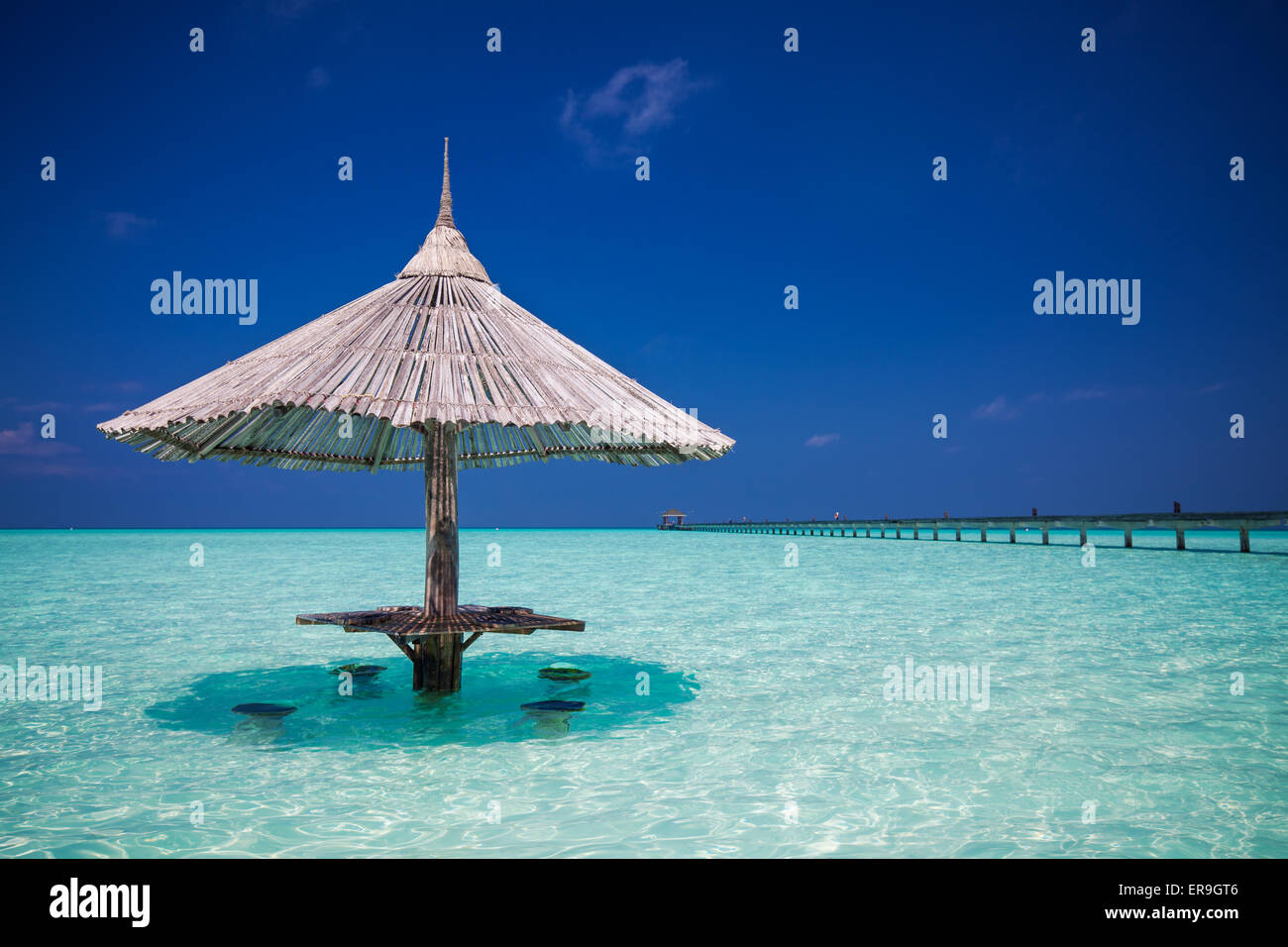 Bambus Sonnenschirm mit bar Plätze im Wasser auf den Malediven Stockfoto