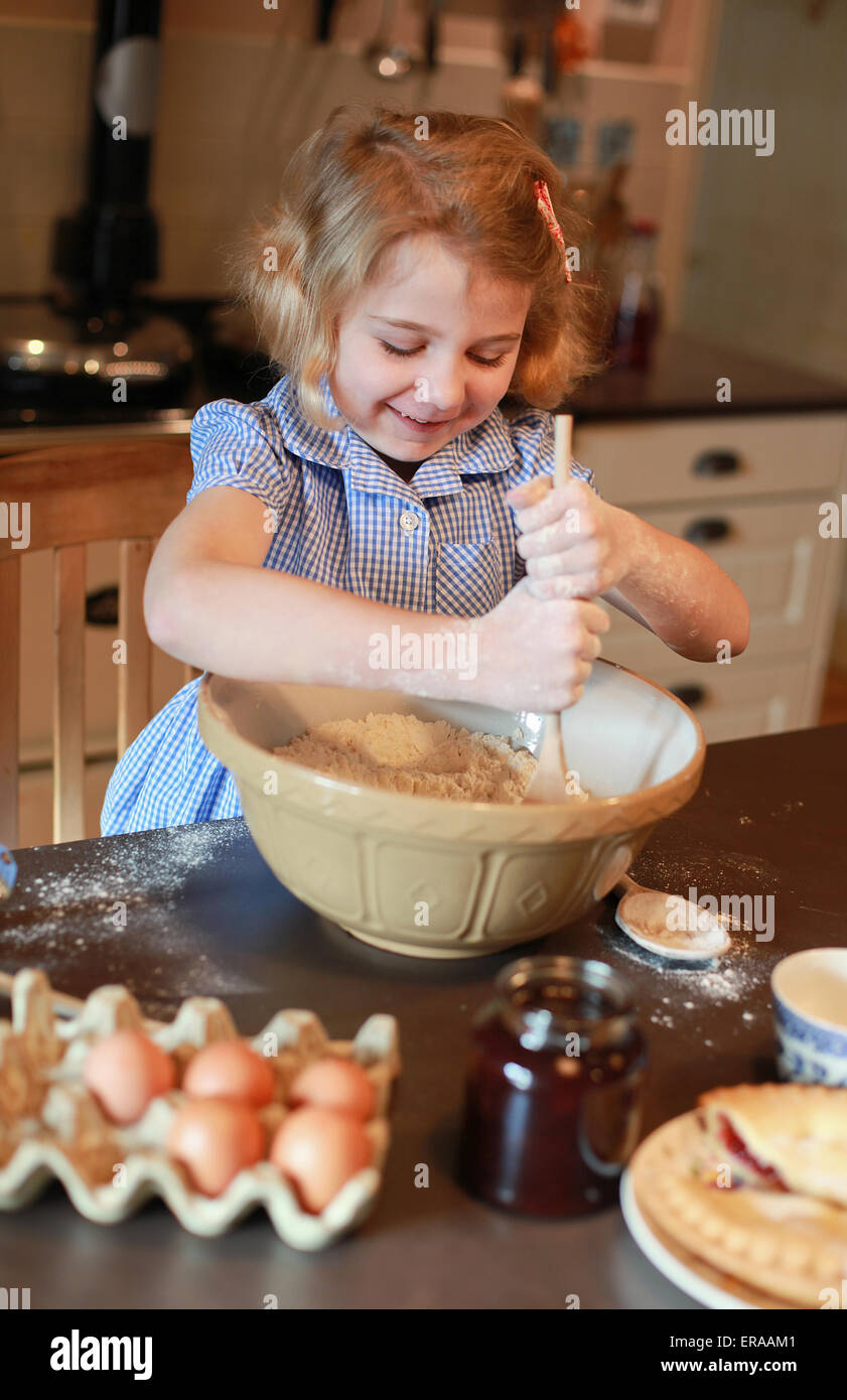 Hübsche blonde kurzhaarige Mädchen Zutaten in einer Schüssel mischen Stockfoto