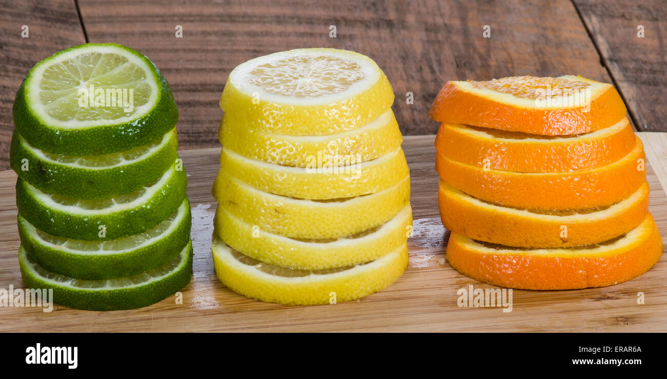 Stapel von Zitrone, Limette und Orange Scheiben auf Schneidebrett Stockfoto