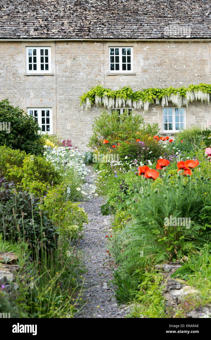 Blumengarten und Weg vor einem Haus in Ablington. Cotswolds, Gloucestershire, England Stockfoto