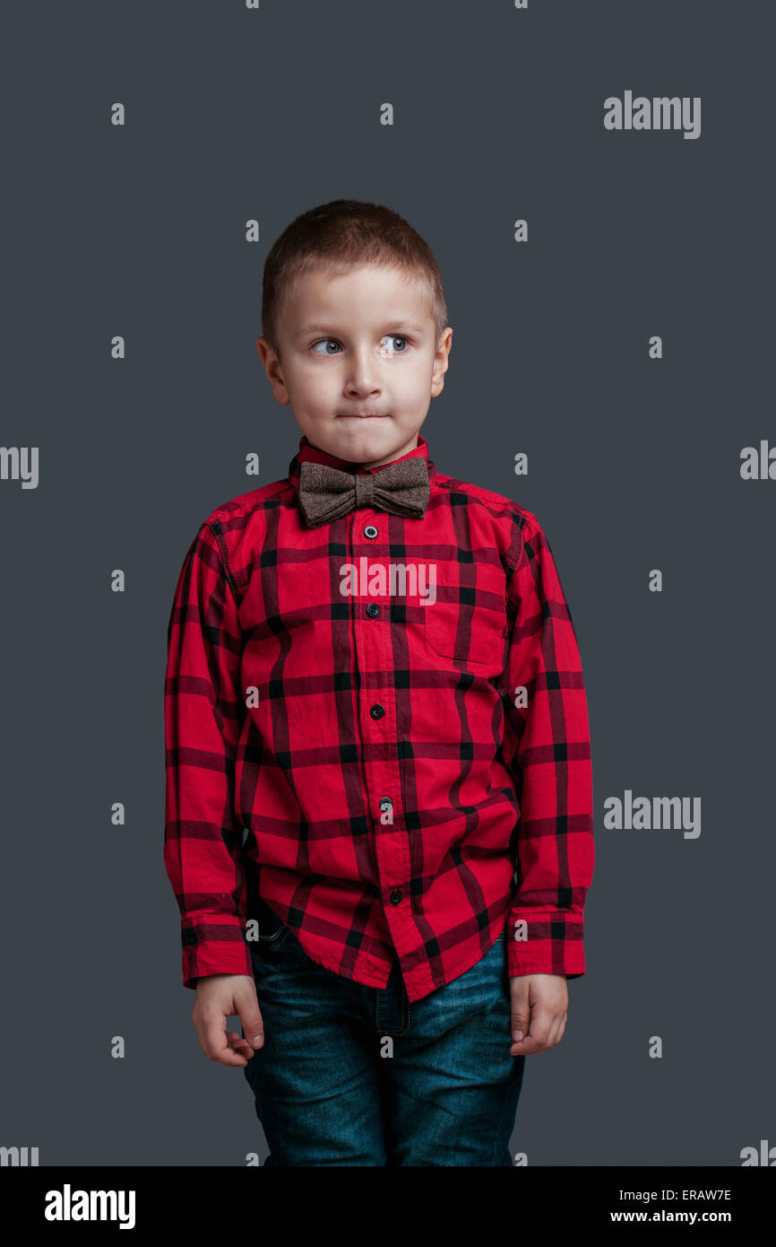 Porträt eines kleinen Jungen mit Emotion auf dunklem Hintergrund isoliert Stockfoto