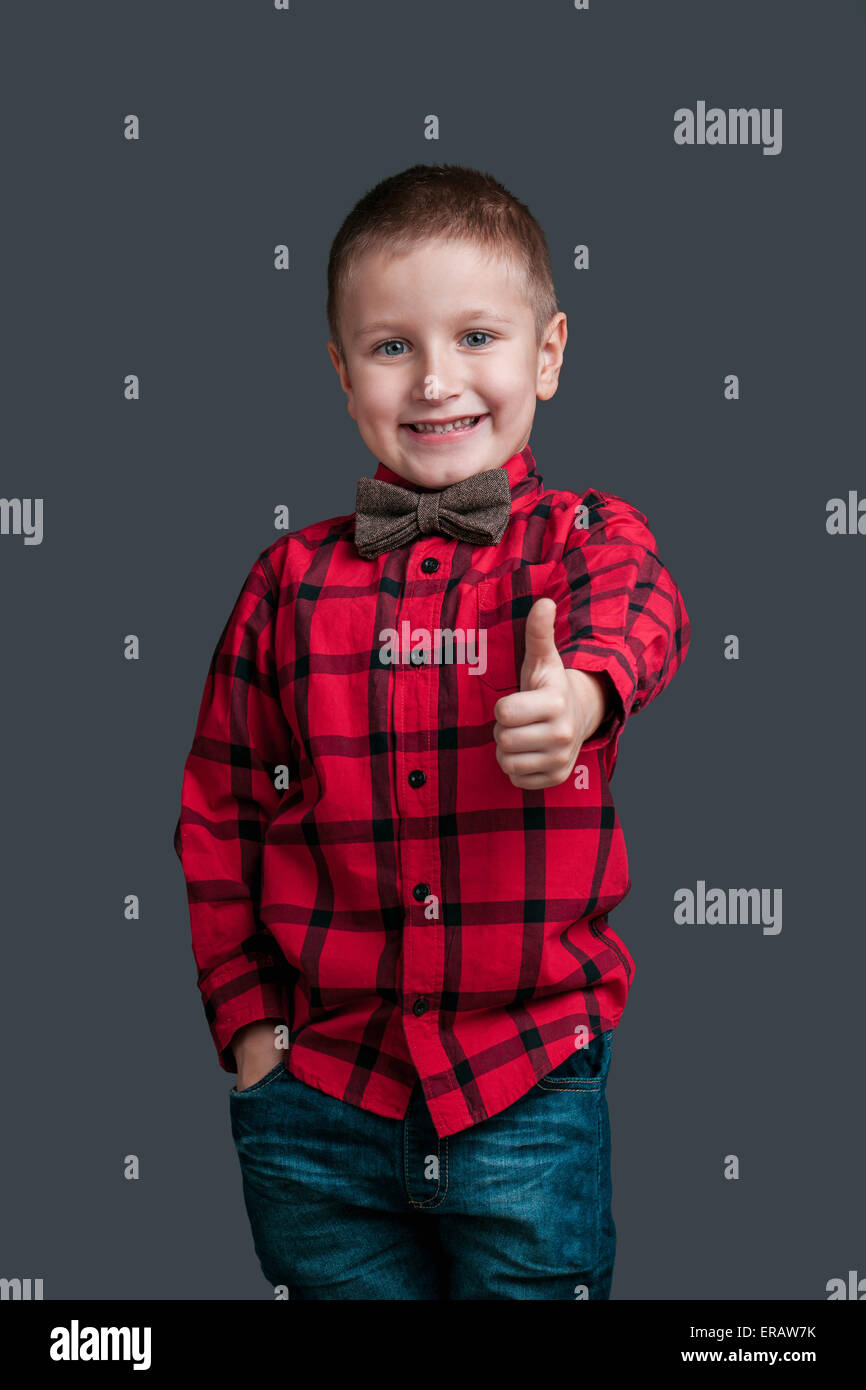 Porträt eines kleinen Jungen in einem Shirt Emotion auf seinem Gesicht auf dunklem Hintergrund isoliert Stockfoto