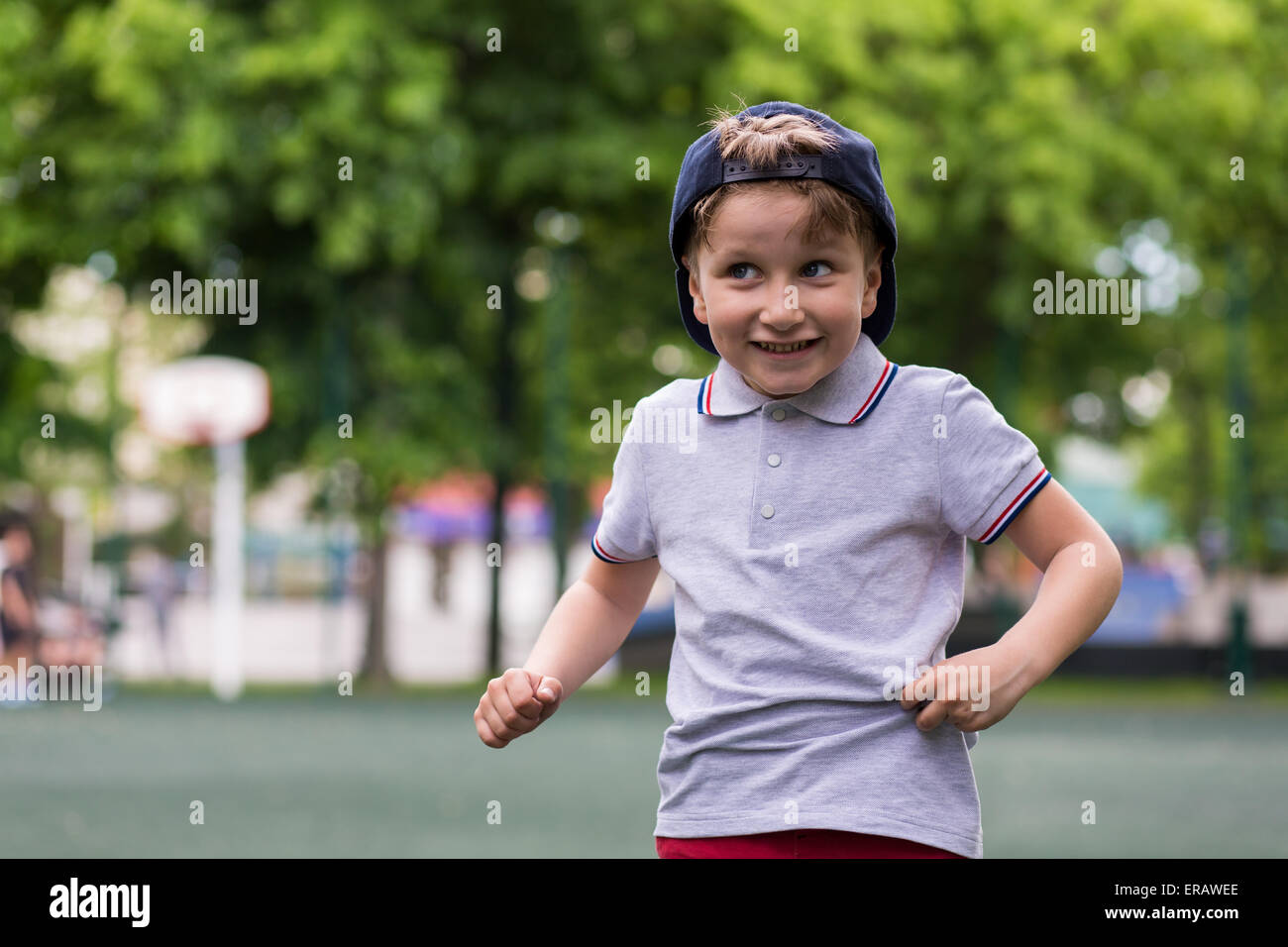 Glückliche kleine Junge lächelnd jemanden im Park begrüßen Stockfoto