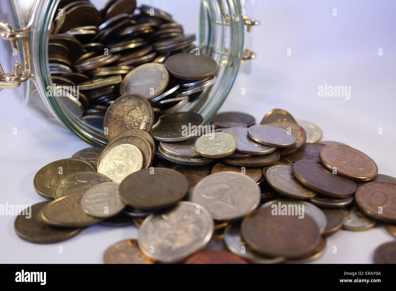 Münzen aus dem Glas zu verschütten Stockfoto
