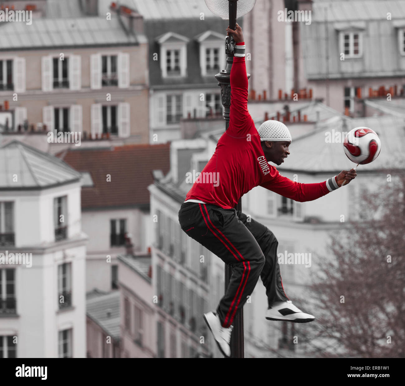 Straßenkünstler Ausgleich einen Spinnen-Fußball beim Klettern auf einer Straßenlaterne Montmartre Paris Frankreich Europa Stockfoto
