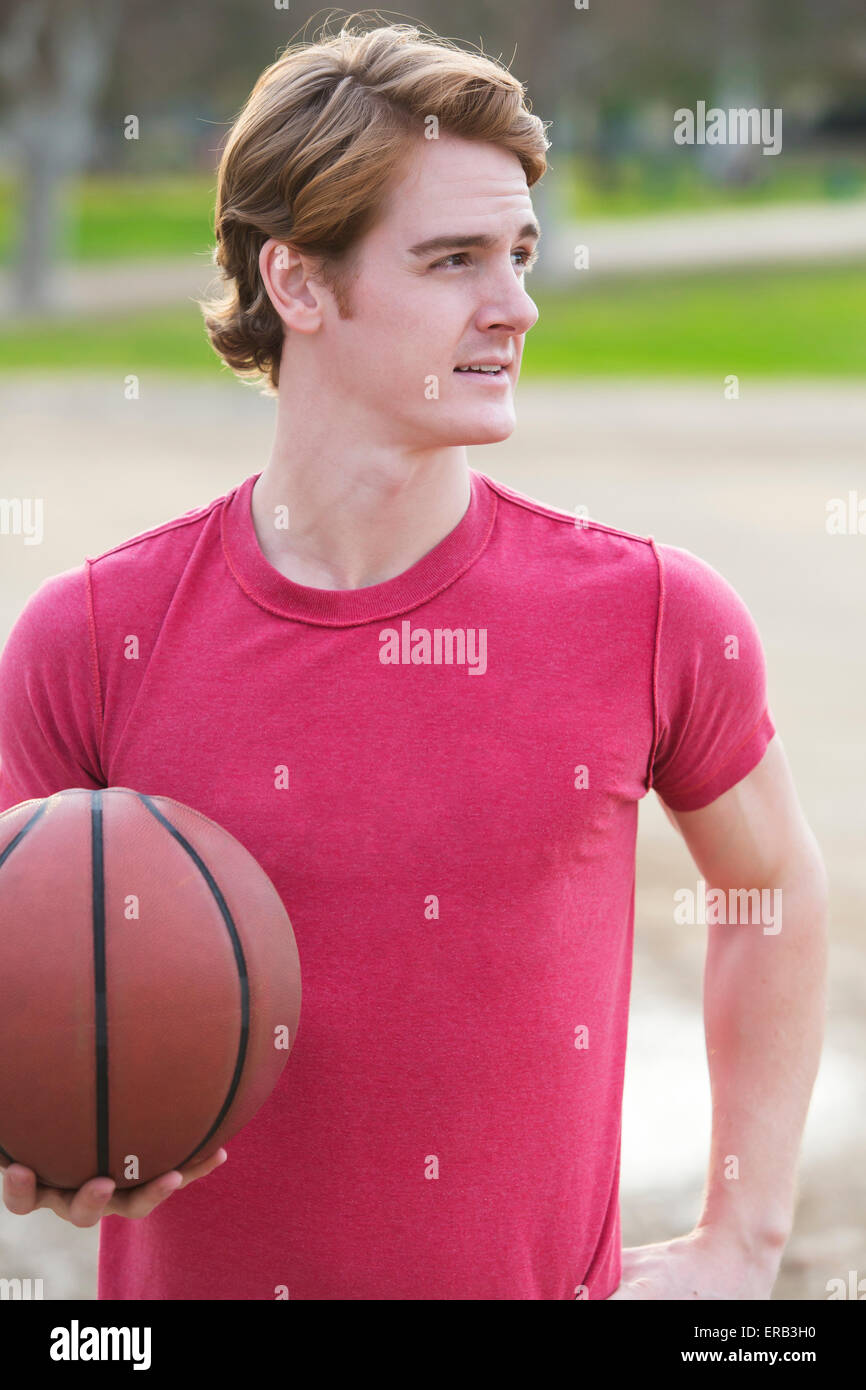 junger Mann mit Basketball in seinen Händen Stockfoto
