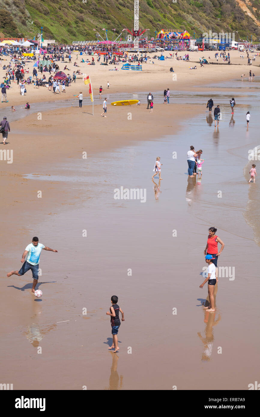 Besucher Ball spielen und Vergnügen sich am Strand von Bournemouth, das Beste aus den heißen, sonnigen Wetter in im Mai zu machen. Stockfoto