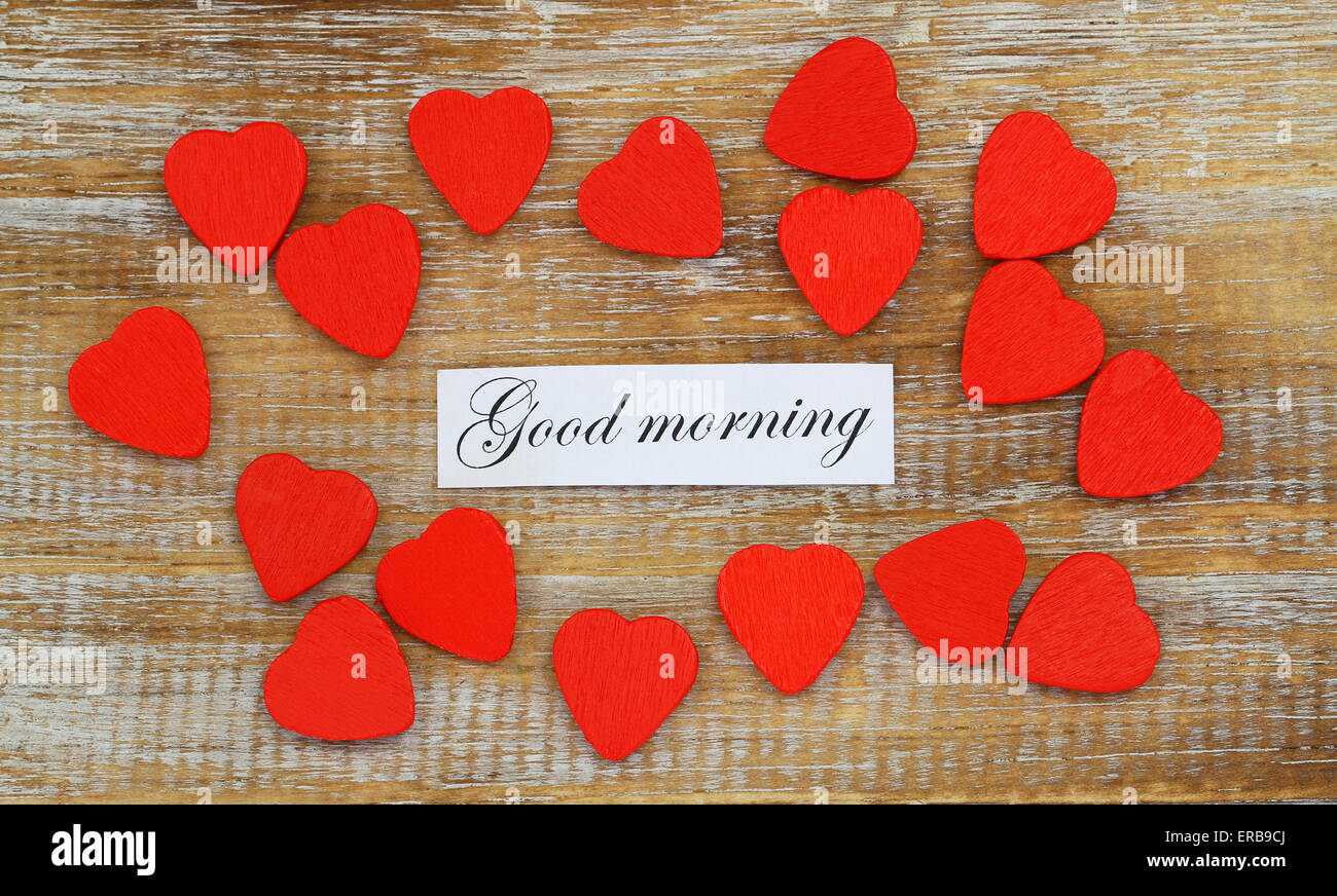 Guten Morgen Karte mit kleinen roten Holzherzen auf rustikalen Holz Stockfoto