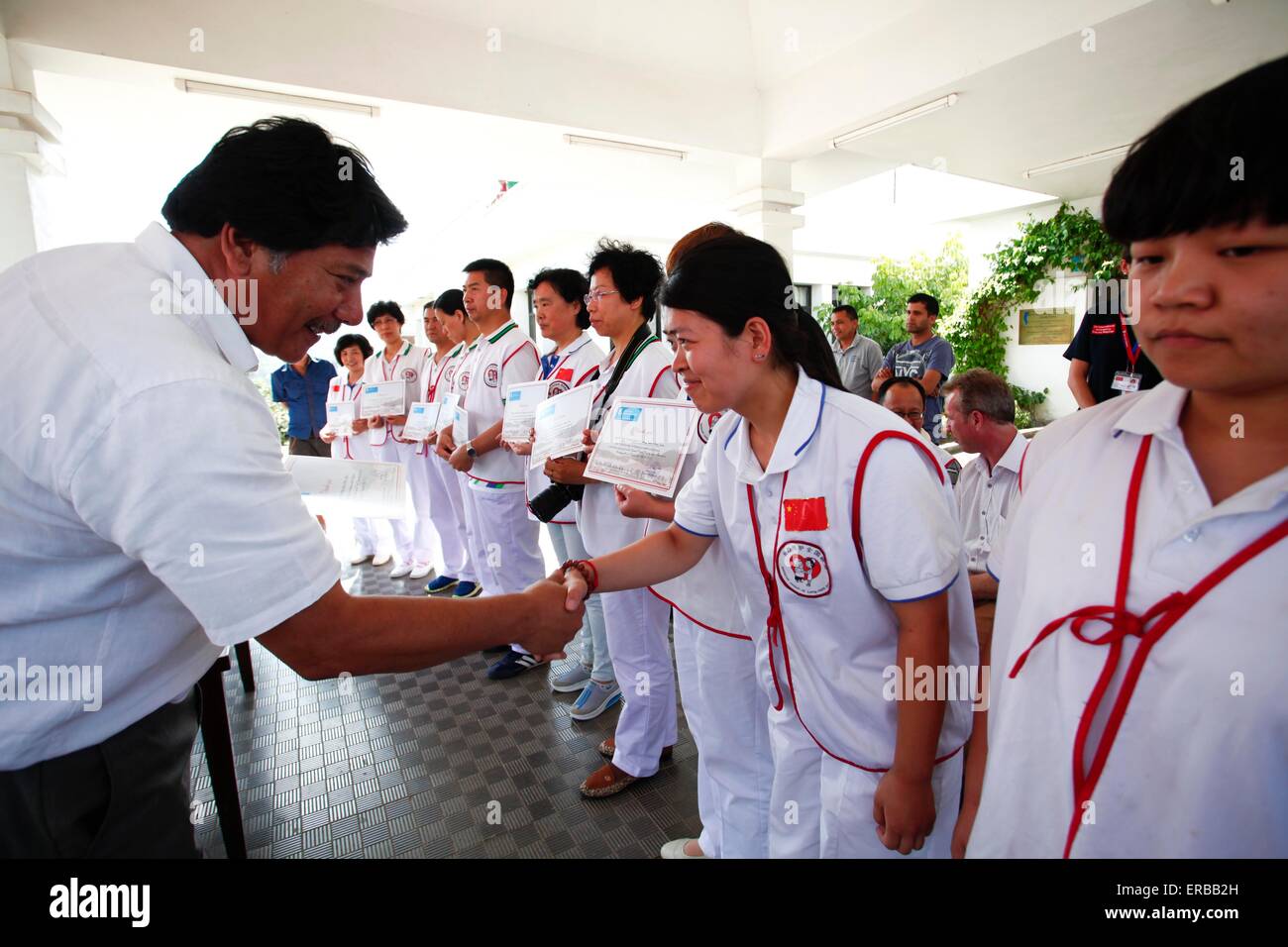 Kavre, Nepal. 31. Mai 2015. Prachanda Bahadur Shrestha (L), Vorsitzender der spinalen Verletzung Rehabilitationszentrum, schüttelt Hände mit einem Mitglied aus China Charity Föderation Long-Term Care International Katastrophenhilfe freiwillige Pflege-Service-Gruppe während einer Spendenübergabe in Kavre, Nepal, 31. Mai 2015. China Charity Föderation Long-Term Care Group gespendet medizinische Hilfsmittel wie Rollstühle, Closestools und andere Ausrüstungen nach Nepal am Sonntag. © Pratap Thapa/Xinhua/Alamy Live-Nachrichten Stockfoto