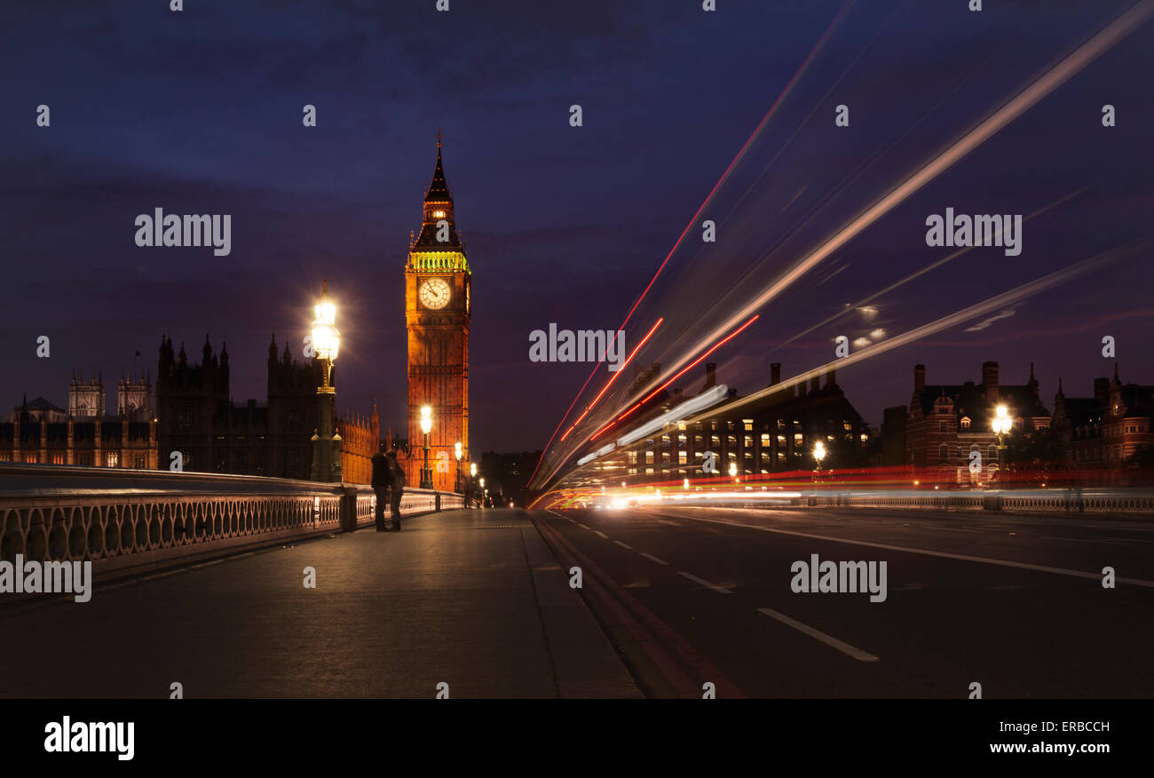 Ein paar Kuss auf der Brücke als ein Doppeldecker-Bus zoomt Vergangenheit der Uhrturm des Palace of Westminster (Big Ben) in London. Stockfoto